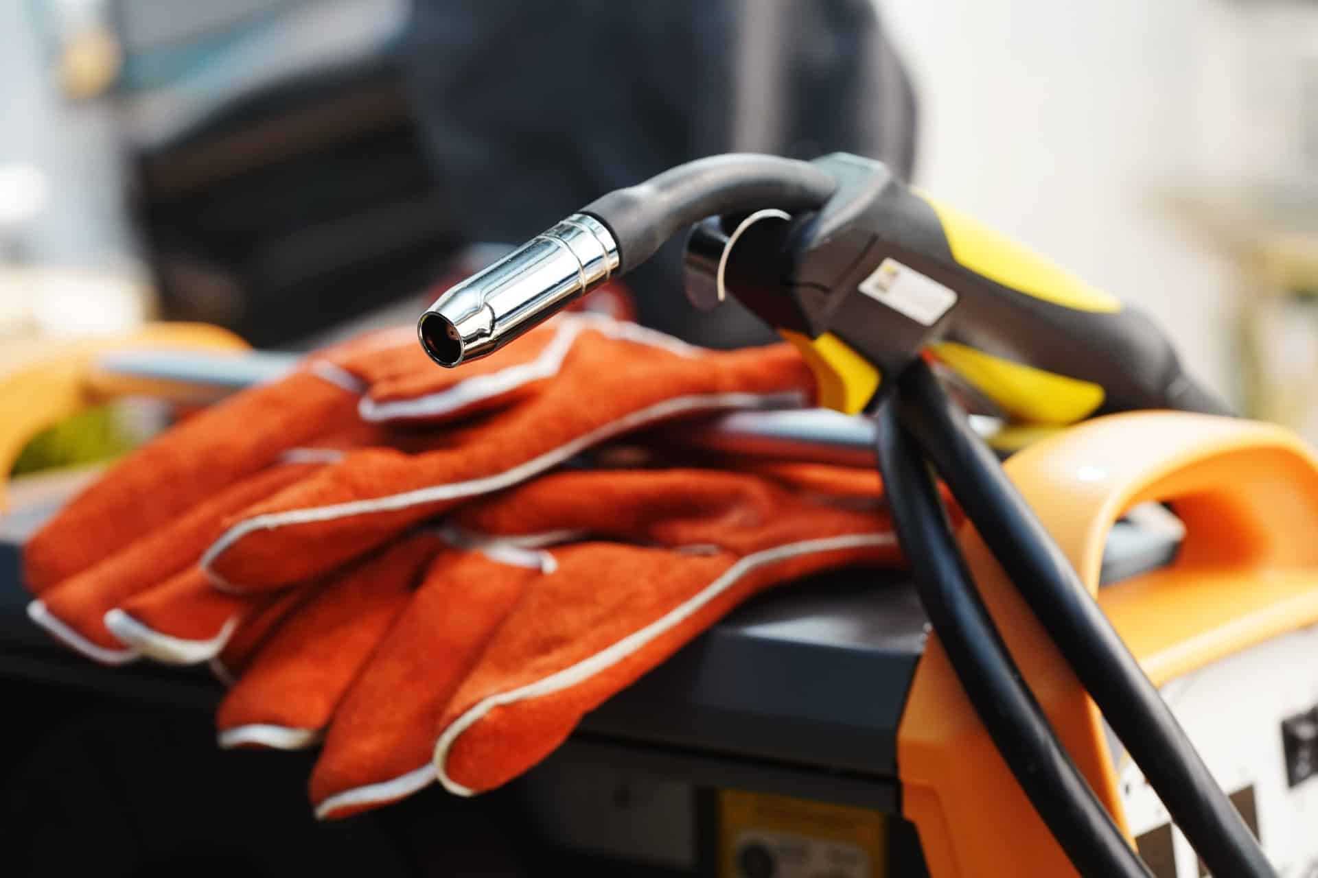MIG- og MAG-sveiseutstyr ligger klart til bruk sammen med oransje sikkerhetshansker