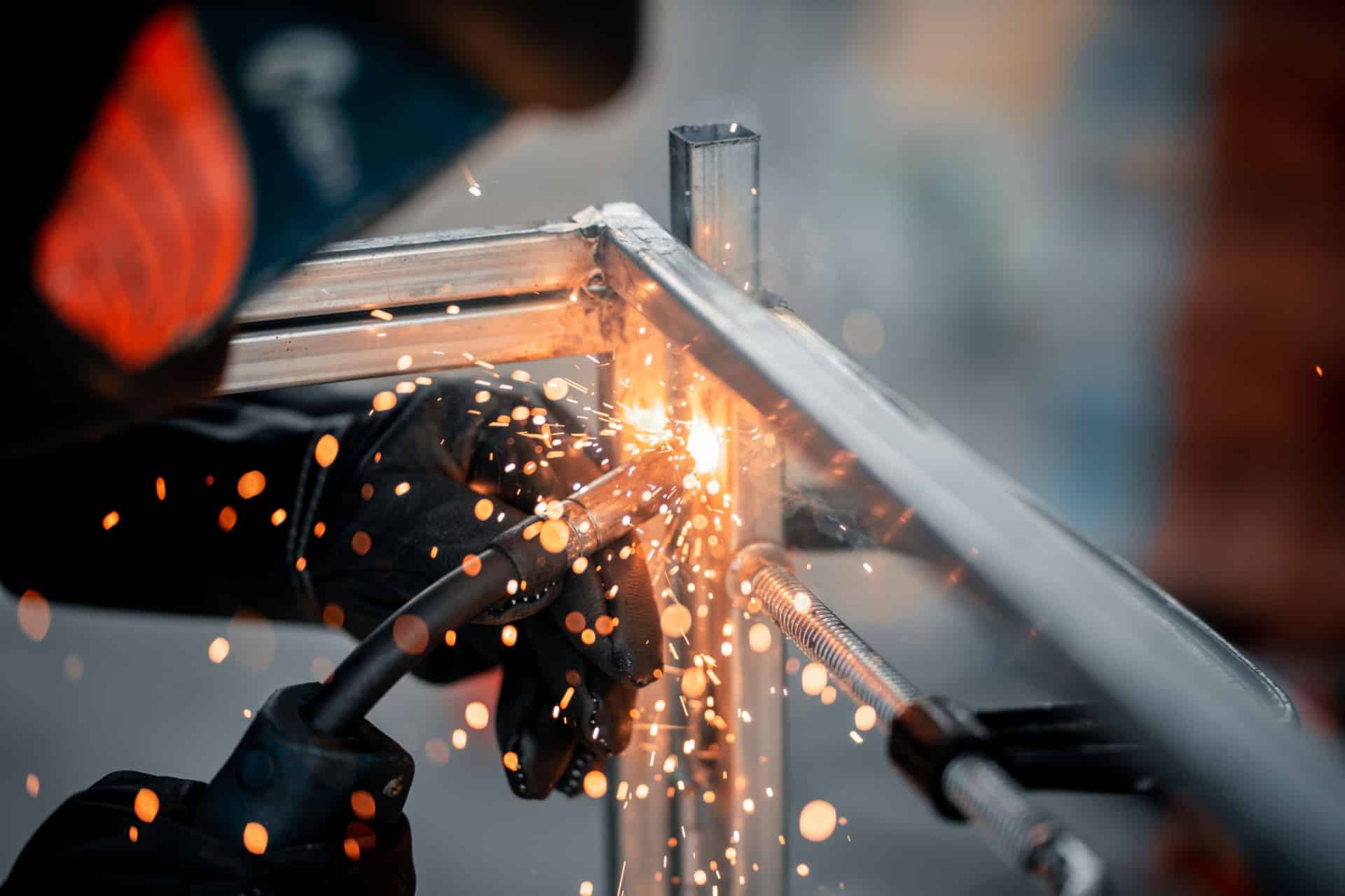 Sveiser / platearbeider som sveiser en stålkonstruksjon nøye med presisjon